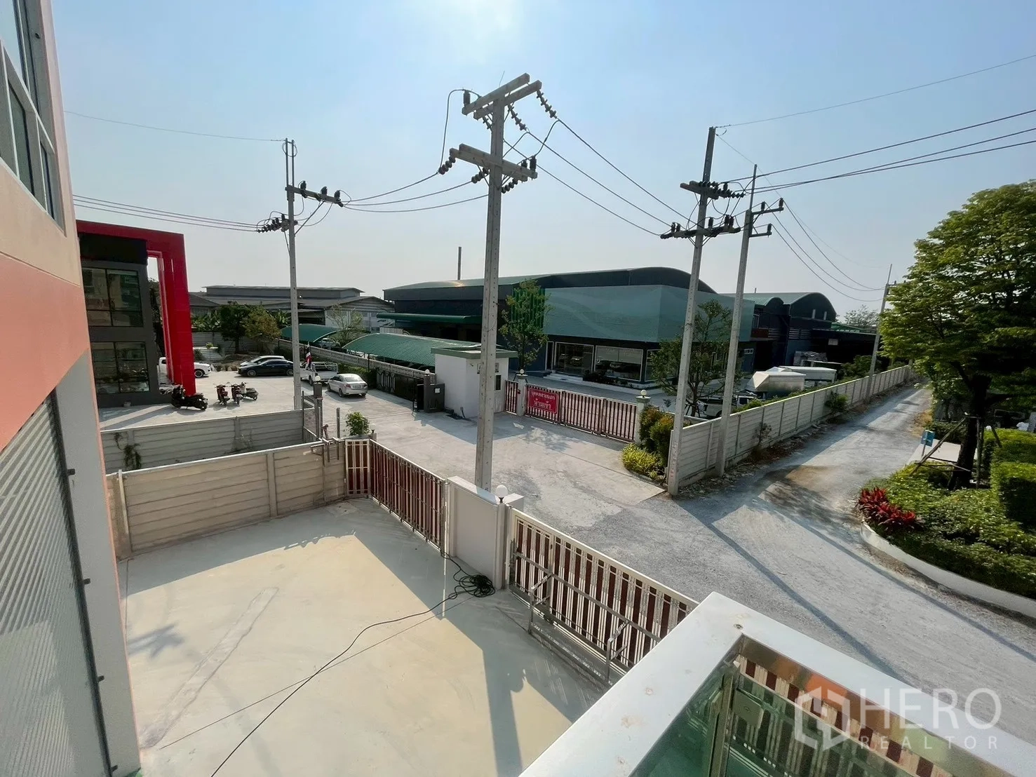 โรงงาน for sale in Sam Phran, Nakhon Pathom - วิวจากระเบียงชั้นบนเห็นลานคอนกรีต ประตูรั้ว และโกดังรอบข้าง