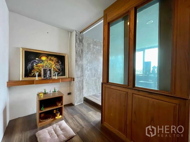 店屋 出租在Lat Phrao, Bangkok - 小型祈祷/冥想角，木柜与装饰画，磨砂玻璃隔断。