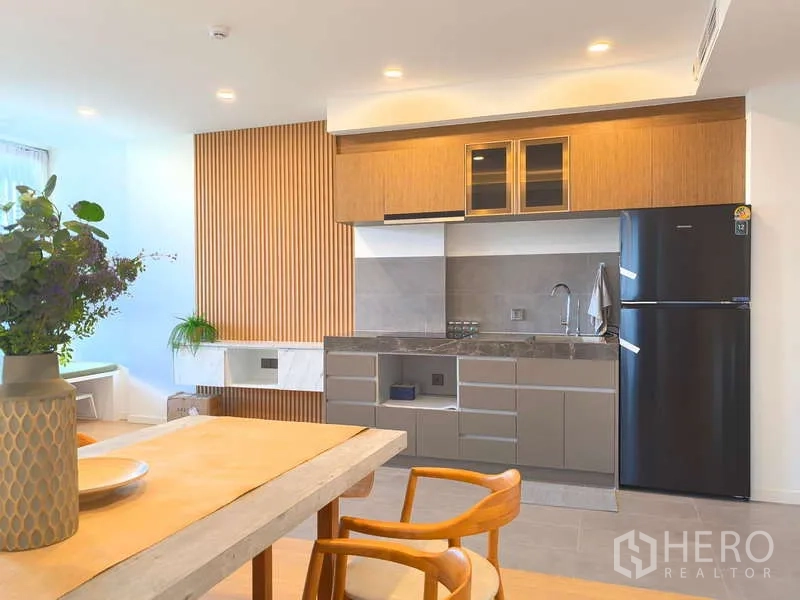 อพาร์ทเมนท์ ให้เช่า - ครัวเปิดพร้อมตู้ไม้ เคาน์เตอร์หิน และตู้เย็นขนาดใหญ่