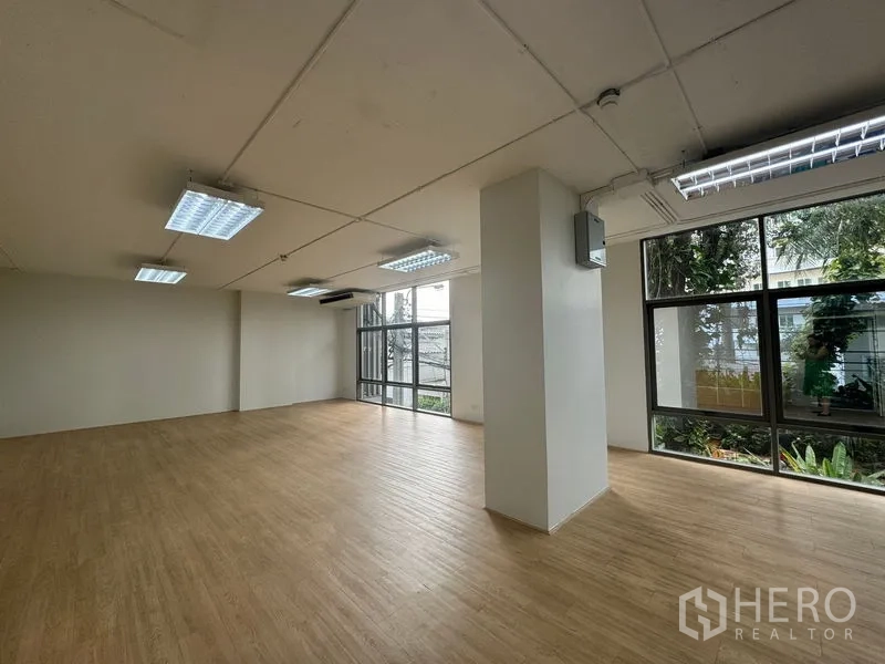 Office Space for rent in Sathon, Bangkok - Open office area with a central column, garden views and abundant natural light.