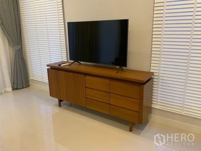 联排别墅 出租在Prawet, Bangkok - 客厅内的木质电视柜与平板电视。