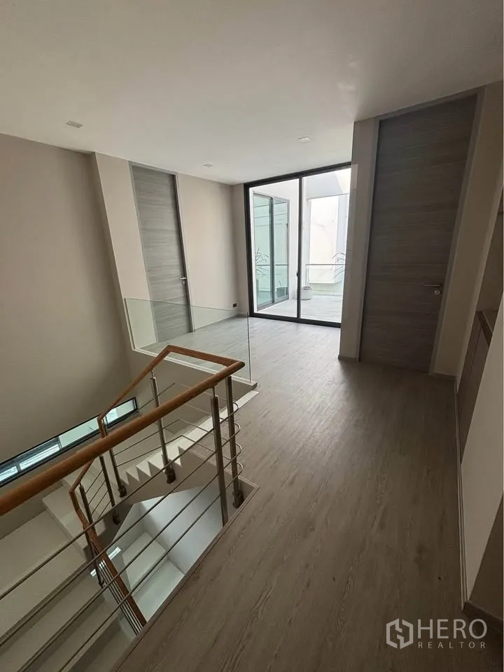 Home Office for rent or sale in Suan Luang, Bangkok - Upper-floor landing with glass balustrade and staircase.