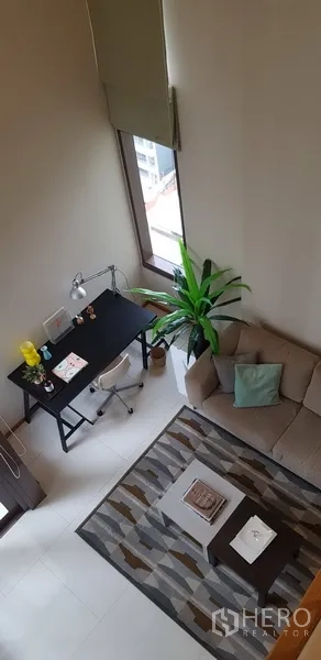 公寓 出租在Khlong Toei, Bangkok - 温馨起居区，含书桌、沙发与地毯，采光充足。