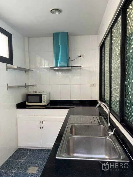ทาวน์เฮาส์ ให้เช่าในKhlong Toei, Bangkok - ครัวไทยแยกต่างหาก พร้อมอ่างล้างจานคู่ เคาน์เตอร์ดำ เครื่องดูดควัน และหน้าต่างบานเลื่อน