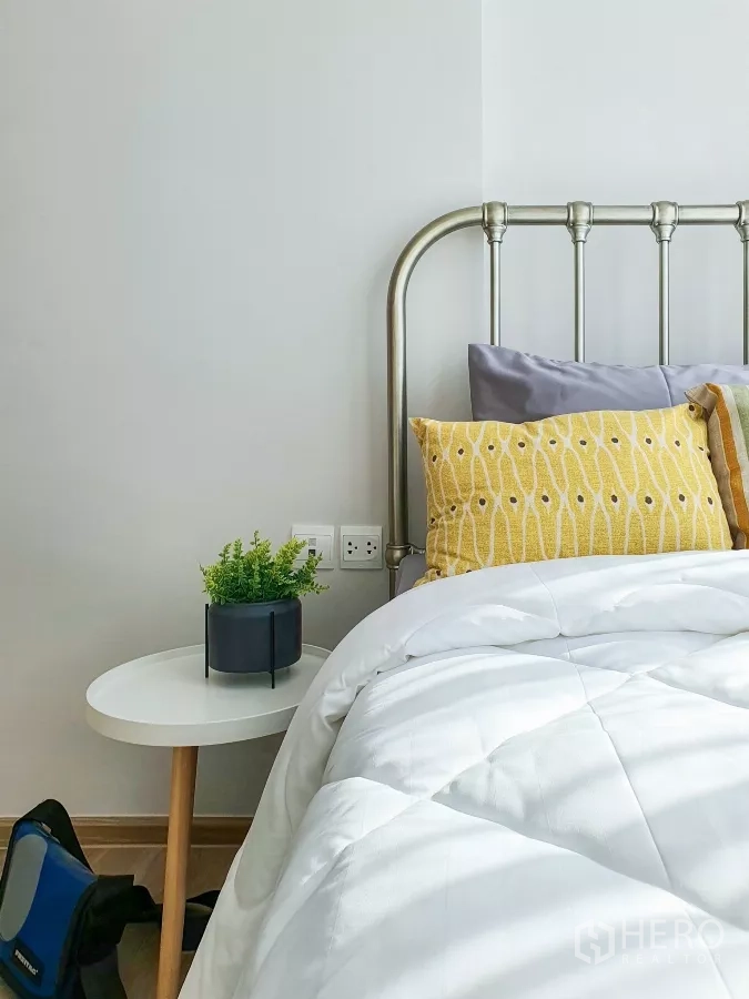 คอนโด ให้เช่าในKhlong Toei, Bangkok - รายละเอียดเตียง หมอนสีเหลือง ผ้าห่มสีขาว และกระถางต้นไม้เล็ก