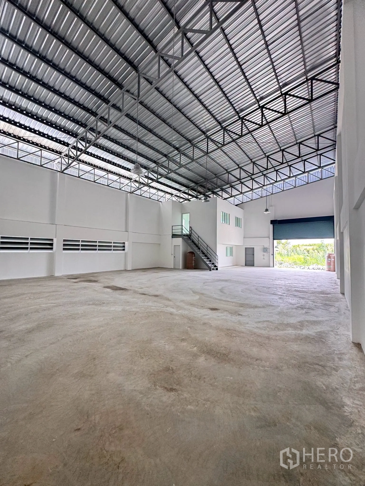 โกดัง for rent in Bang Bo, Samut Prakan - มองไปยังประตูม้วนขนาดใหญ่บริเวณลานขนถ่ายและบันไดชั้นลอย