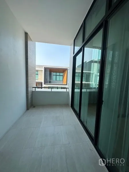 ทาวน์เฮาส์ ขายในSaphan Sung, Bangkok - ระเบียงมีหลังคา ราวกระจก มองเห็นทาวน์โฮมสมัยใหม่ฝั่งตรงข้าม