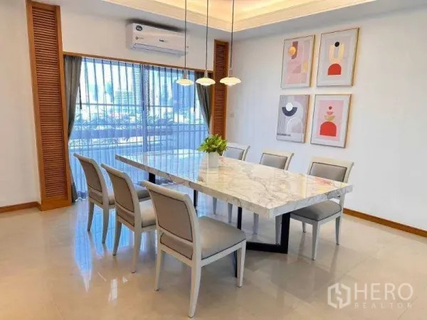 Apartment for rent - Dining room with long marble table, pendant lights and a city view through sheer curtains.
