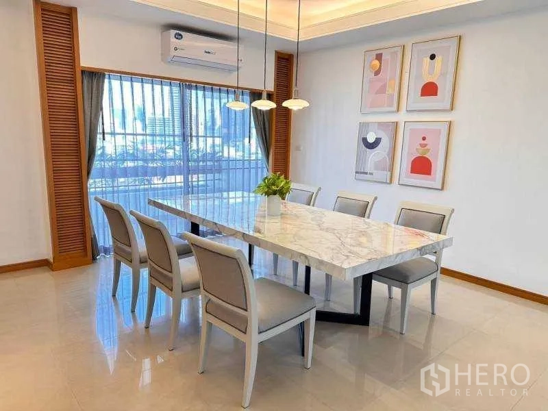 Apartment for rent - Dining room with long marble table, pendant lights and a city view through sheer curtains.