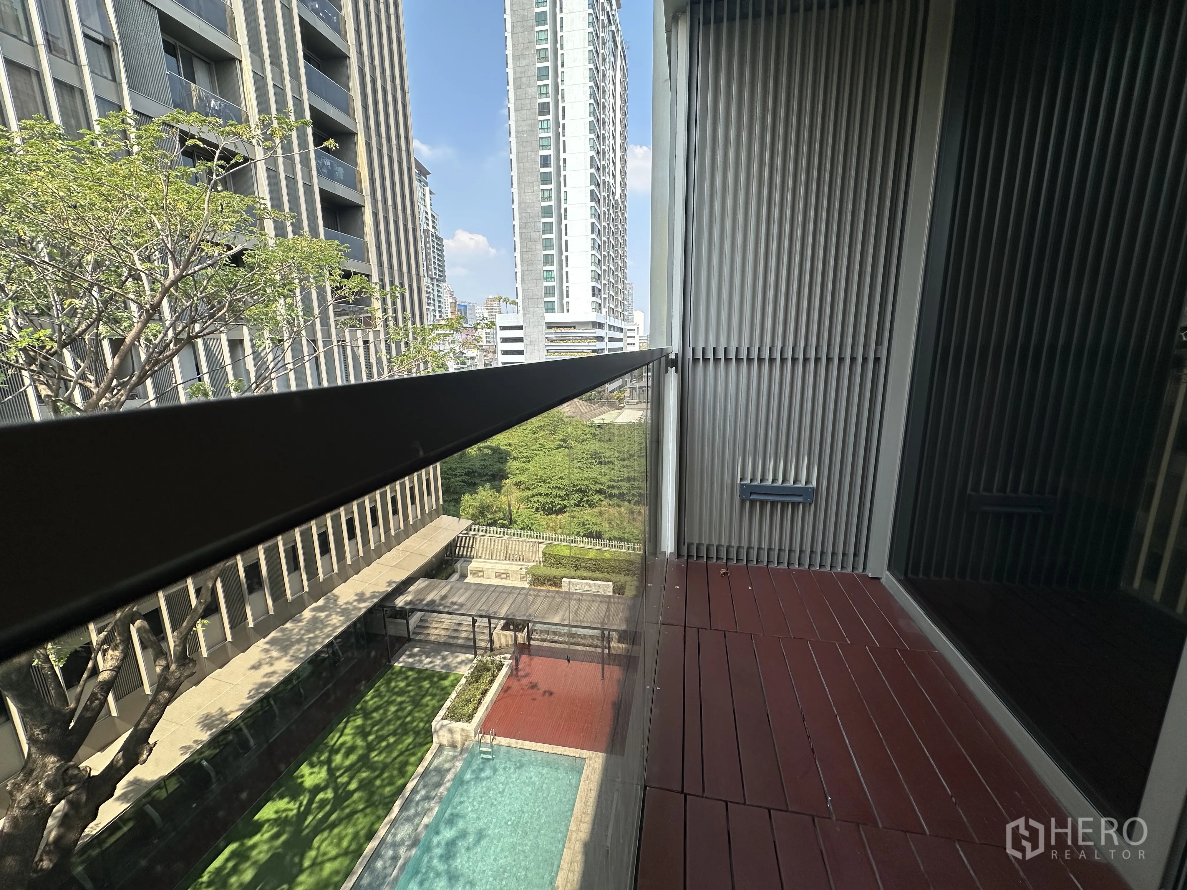 คอนโด for rent in Khlong Toei, Bangkok - ระเบียงส่วนตัวพื้นไม้ มองเห็นสระว่ายน้ำและอาคารโดยรอบ
