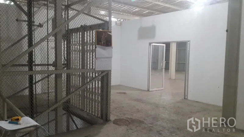 Home Office for rent in Bang Khen, Nonthaburi - Caged freight elevator beside an office doorway inside the warehouse.