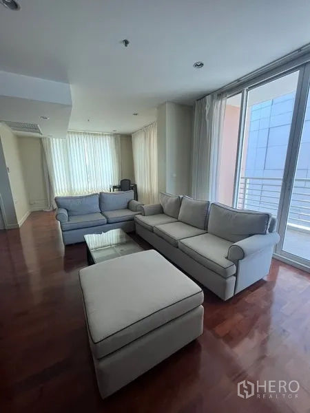 คอนโด ให้เช่าในKhlong Toei, Bangkok - พื้นที่นั่งเล่นพร้อมโซฟาคู่ โต๊ะกลาง และประตูกระจกบานเลื่อนออกสู่ระเบียงในคอนโดกรุงเทพฯ