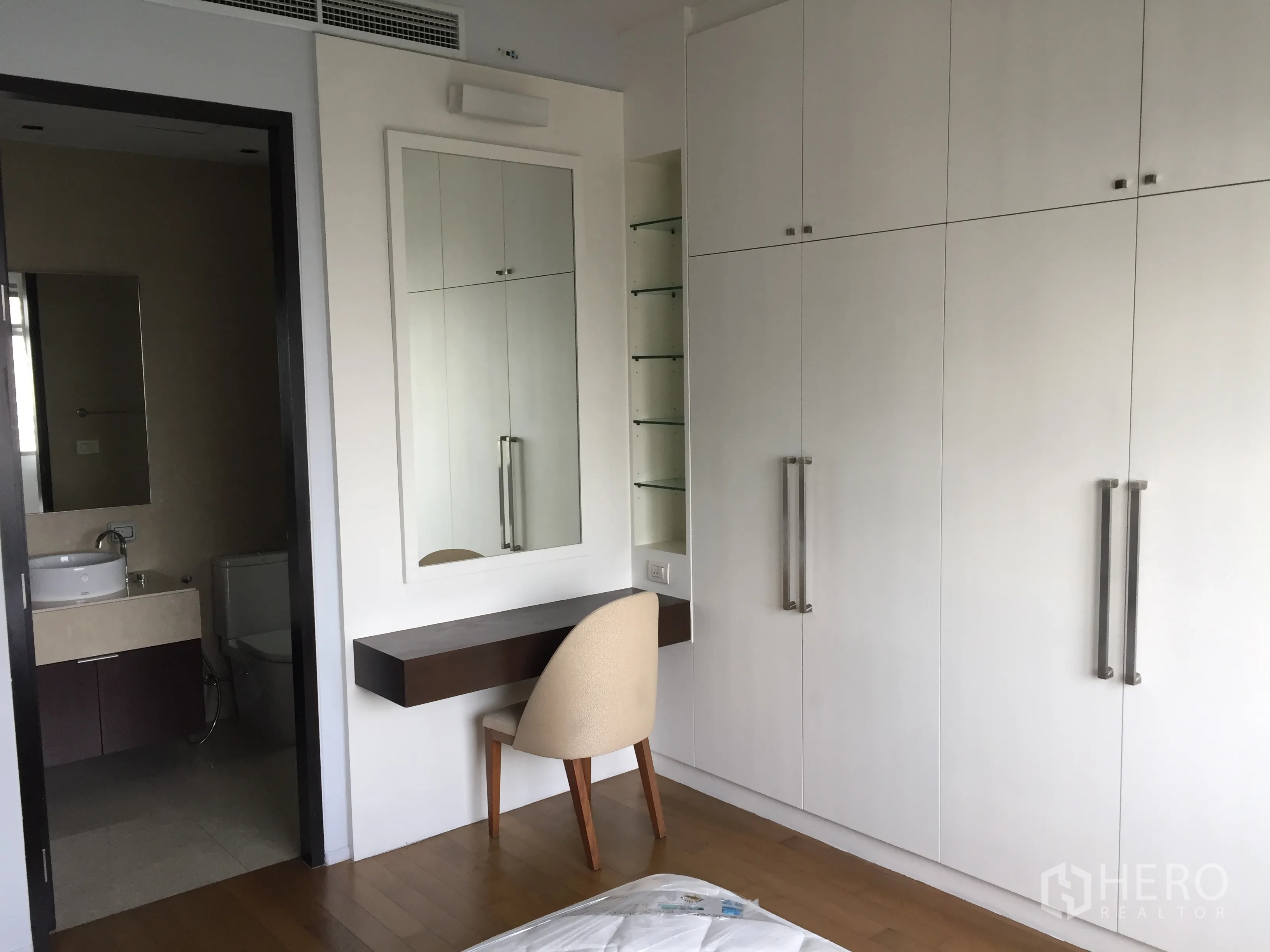 คอนโด ให้เช่าในWatthana, Bangkok - มุมห้องนอนหลักพร้อมตู้เสื้อผ้าสูงเต็มผนัง โต๊ะเครื่องแป้ง และทางเข้าห้องน้ำในตัว