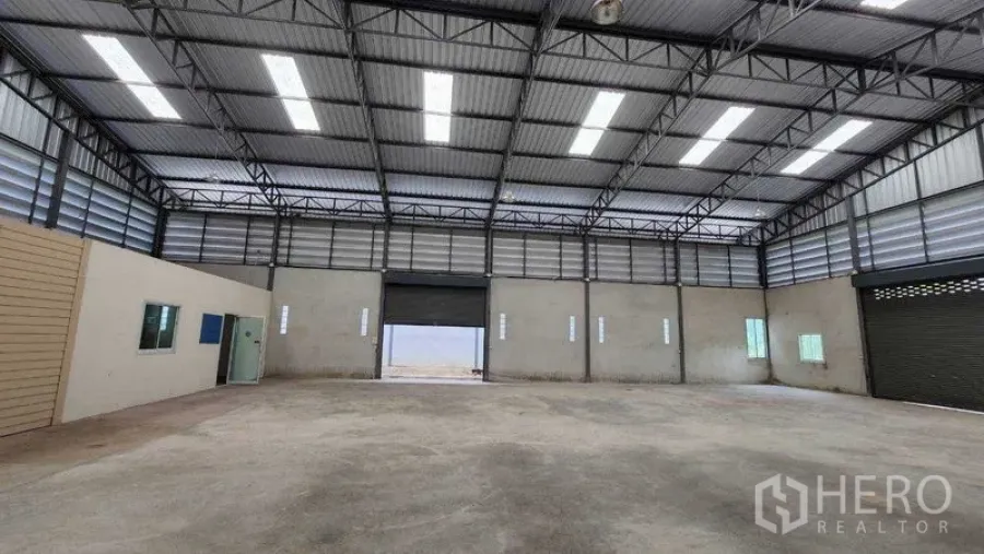 คลังสินค้า ให้เช่าในChon Buri - ภาพมุมกว้างของโกดัง เพดานสูงพร้อมประตูม้วนกลางอาคาร