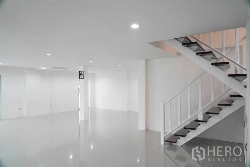 Detached House for sale in Bang Bon, Bangkok - Spacious open‑plan living area with glossy floors, recessed lighting and a staircase.