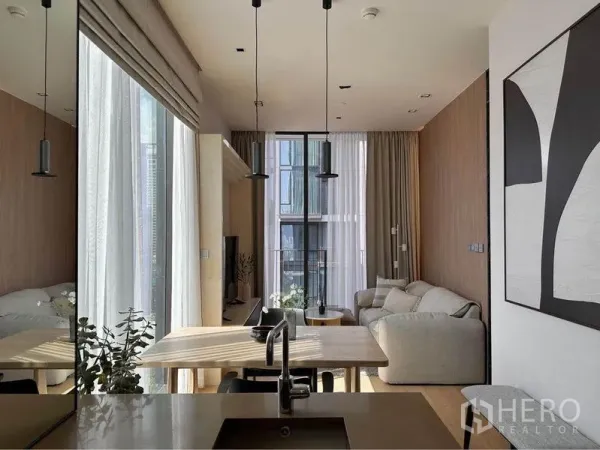 公寓 出租在Pathum Wan, Bangkok - 开放式厨房面向餐桌与客厅，吊灯与通高玻璃让空间通透。