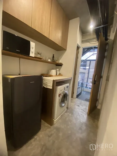 店屋 出租或出售在Khlong Toei, Bangkok - 家务走廊配洗衣机、冰箱与顶柜，功能齐全。