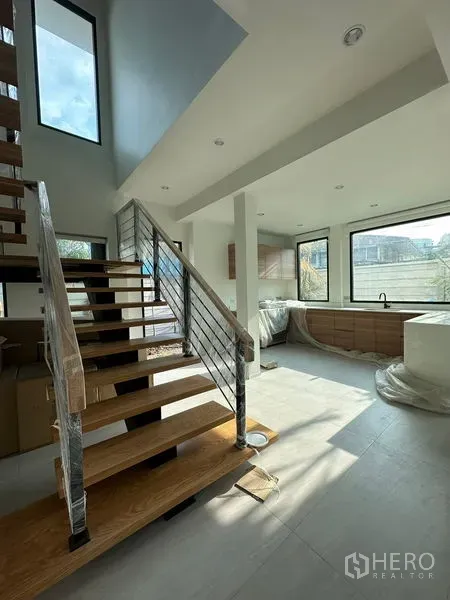 บ้าน ให้เช่าในWatthana, Bangkok - ห้องนั่งเล่นแบบโอเพ่นสเปซสว่างโปร่ง บันไดลอยไม้ และหน้าต่างบานใหญ่ติดครัวโมเดิร์น