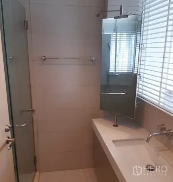 คอนโด ให้เช่าในKhlong Toei, Bangkok - ห้องน้ำสะอาด มีตู้กระจกอาบน้ำ เคาน์เตอร์อ่างล้างหน้ายาว กระจกติดผนัง และมู่ลี่หน้าต่าง