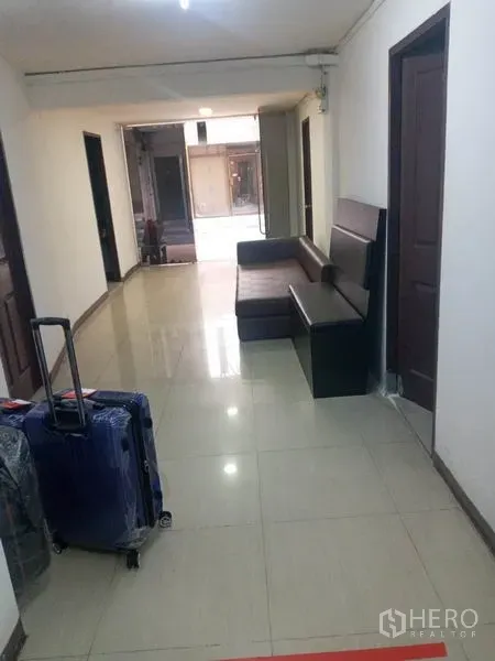 零售空间 出租在Khlong Toei, Bangkok - 明亮的走廊，瓷砖地面，棕色沙发和多扇房门