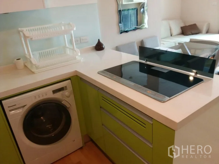 คอนโด ให้เช่าในPhaya Thai, Bangkok - ครัวขนาดกะทัดรัดพร้อมเตาแม่เหล็กไฟฟ้า เครื่องซักผ้า และตู้สีเขียว