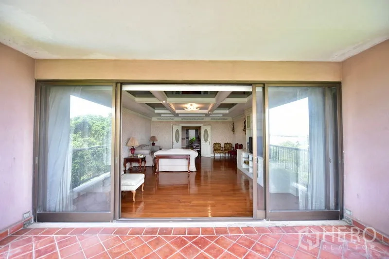 คอนโด ขายในPak Kret, Nonthaburi - มุมมองจากระเบียงแบบครอบคลุมเข้าสู่ห้องนั่งเล่นผ่านประตูกระจกบานเลื่อนกว้าง