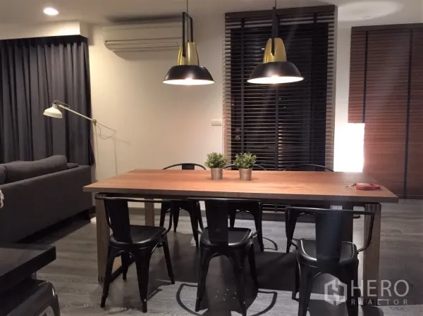 คอนโด ให้เช่าหรือขายในWatthana, Bangkok - มุมทานข้าวโต๊ะไม้ยาว เก้าอี้สีดำ โคมไฟแขวนสไตล์โมเดิร์น พร้อมมู่ลี่และผ้าม่านทึบ