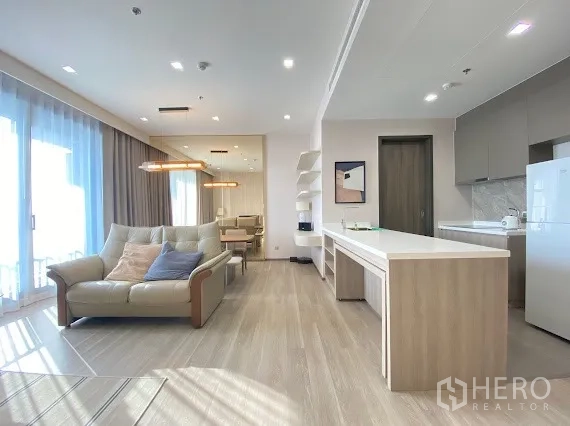 Condominium for rent in Bang Kho Laem, Bangkok - Bright open-plan living and kitchen with island counter, sofa, dining area, and floor-to-ceiling windows in a modern condo.