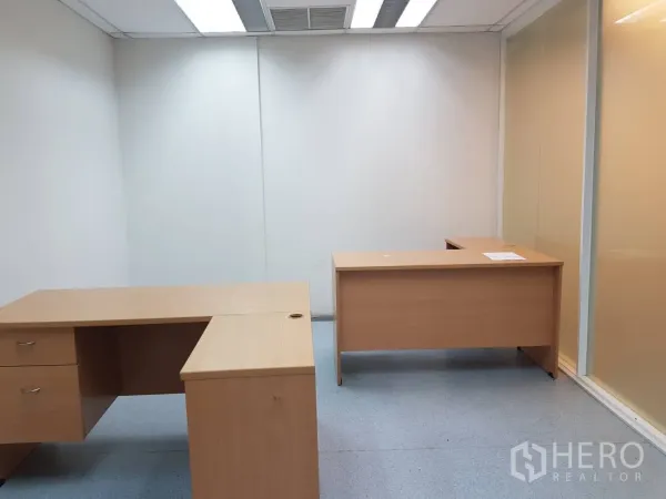 Office Space for rent in Bang Na, Bangkok - Private office featuring two L-shaped desks, frosted glass partition, and recessed lighting.