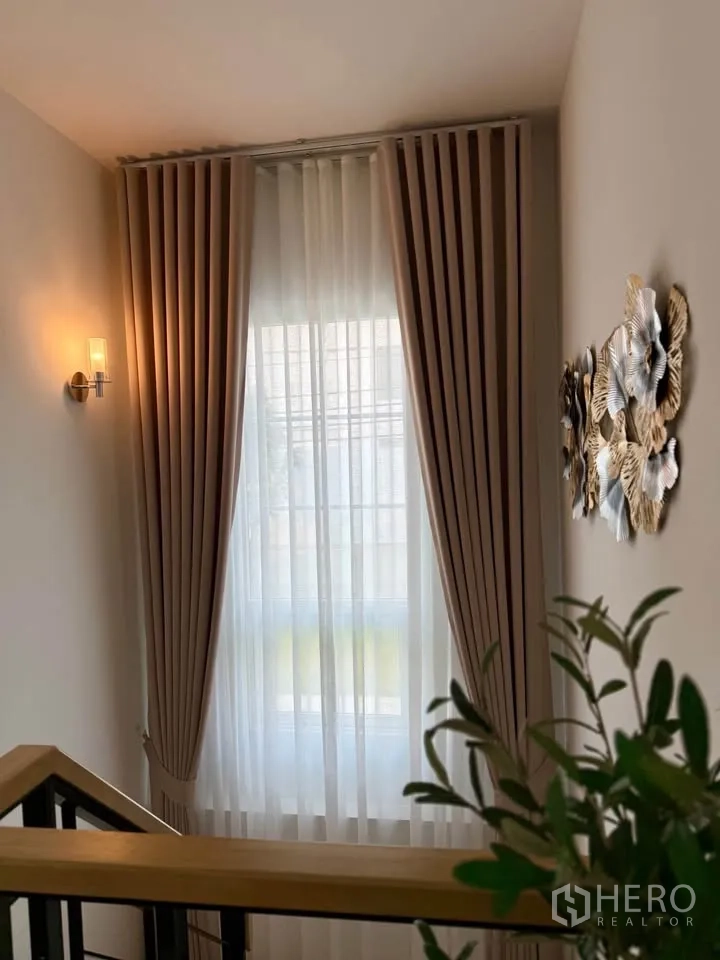 บ้านแฝด for rent in Mueang Samut Prakan, Samut Prakan - ชานพักบันไดมีหน้าต่างสูง ผ้าม่าน และโคมไฟผนัง