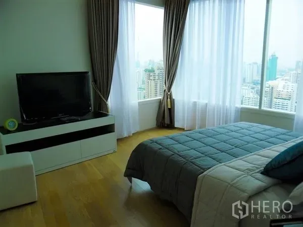 Condominium for rent or sale in Watthana, Bangkok - Bedroom with TV console and wraparound windows offering city views and natural light.