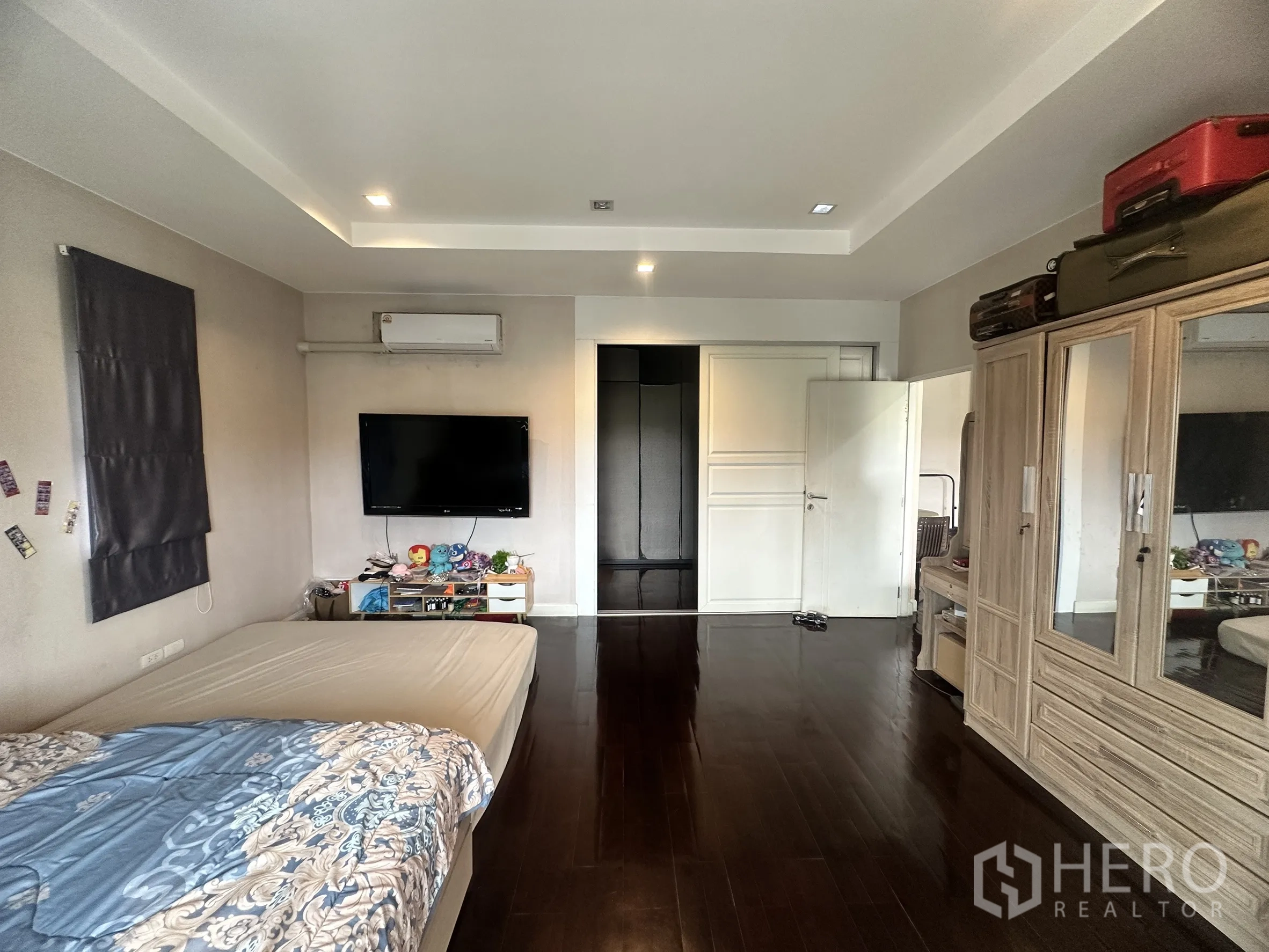 Detached House for sale in Pak Kret, Nonthaburi - Master bedroom angle with wall-mounted TV, wardrobes, and recessed lights.