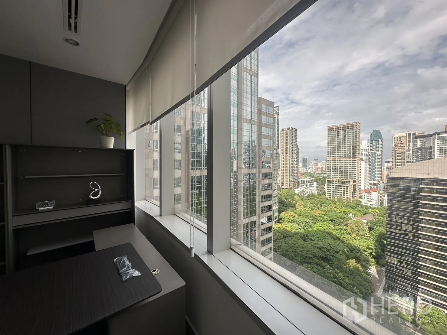 办公室 for rent in Pathum Wan, Bangkok - 私人办公室窗边视角，可见高楼与大片绿树景观。