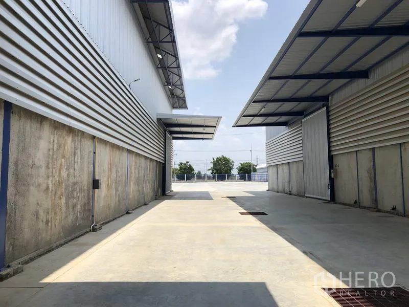 工厂 出租在Lat Lum Kaeo, Pathum Thani - 厂区宽阔车道通向入口，可见道路尽头的树木。