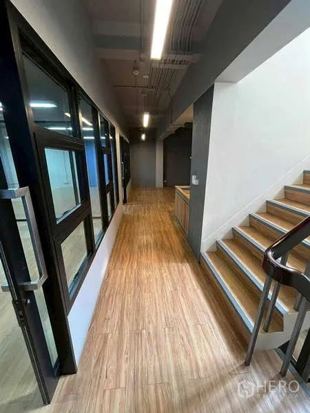 สำนักงาน ให้เช่าในSamphanthawong, Bangkok - โถงทางเดินพื้นลายไม้ ผนังกระจกสำนักงาน และบันไดทางเชื่อมภายใน