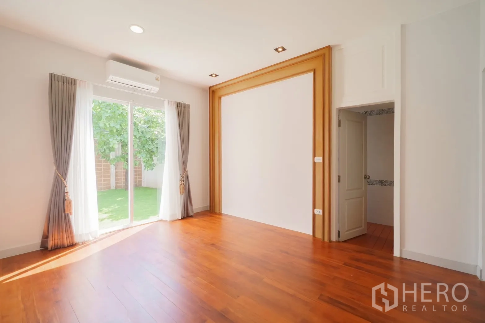 Detached House for rent or sale in Saphan Sung, Bangkok - Ground-floor room with sliding doors opening to the garden.