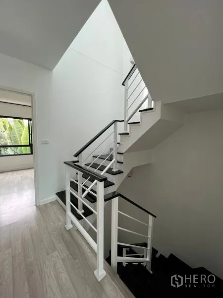 ทาวน์เฮาส์ ขายในBang Kapi, Bangkok - บันไดสไตล์โมเดิร์นโทนขาวดำพร้อมราวโลหะในโถงสว่าง