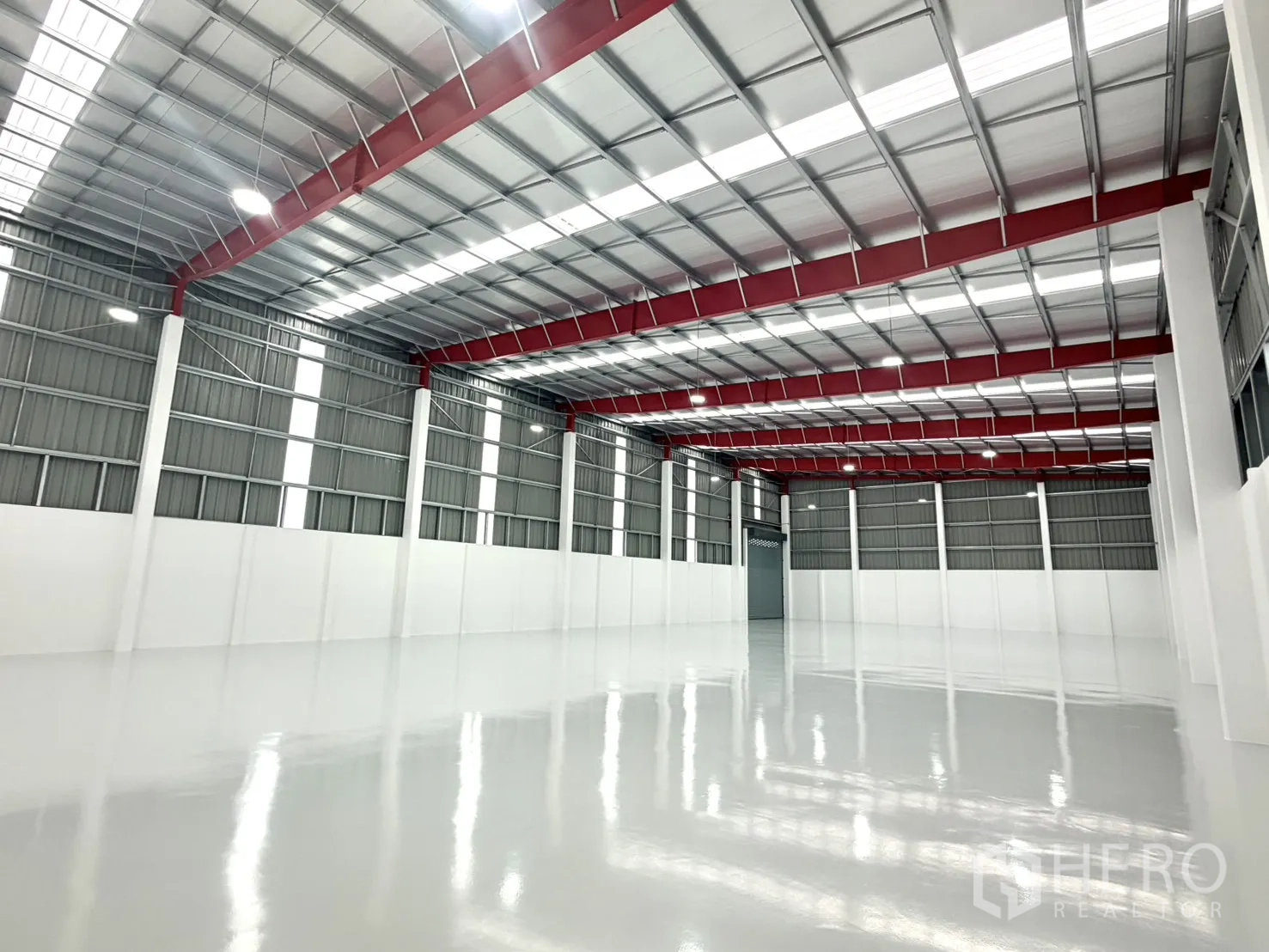 Factory for rent or sale in Lam Luk Ka, Pathum Thani - Spacious warehouse interior with high ceiling and glossy epoxy floor.