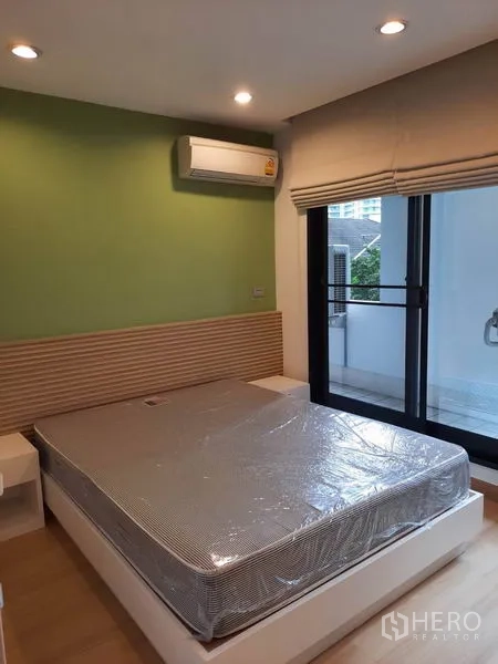 คอนโด ให้เช่าในWatthana, Bangkok - ห้องนอนที่สอง ผนังสีเขียว เครื่องปรับอากาศ และประตูกระจกเชื่อมต่อระเบียง