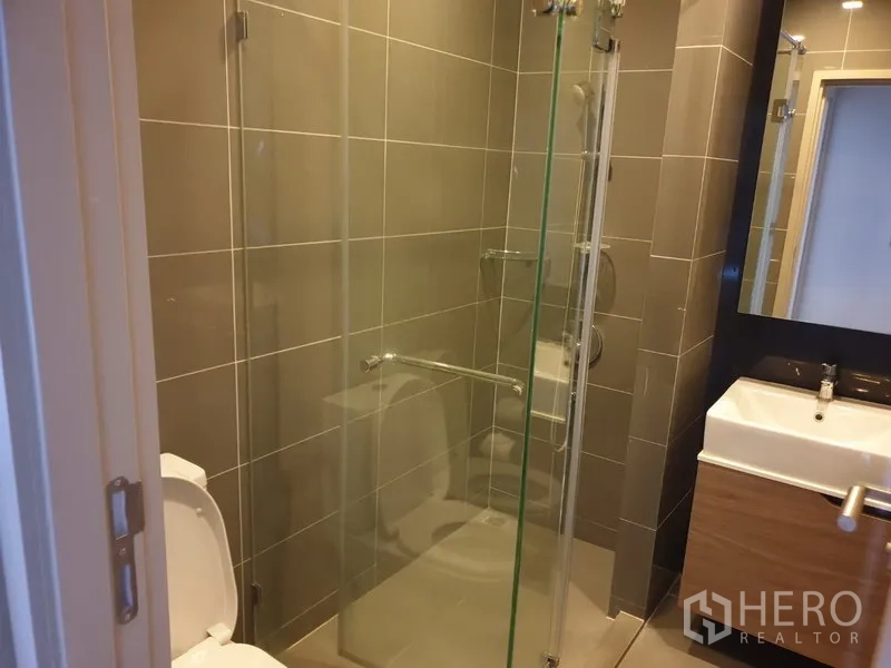 คอนโด ให้เช่าในWatthana, Bangkok - ห้องน้ำพร้อมตู้กระจกกั้นอาบน้ำ ผนังปูกระเบื้อง โถสุขภัณฑ์ และอ่างล้างหน้าพร้อมกระจก