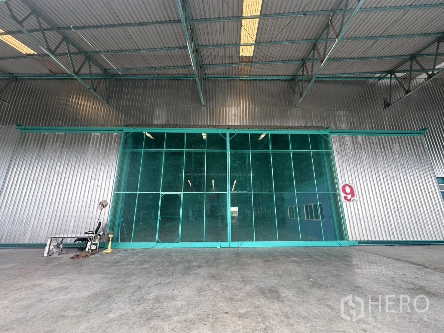 โกดัง for rent in Sai Noi, Nonthaburi - ด้านหน้าโกดังพร้อมประตูบานเลื่อนขนาดใหญ่และลานรับส่งสินค้ามีหลังคา