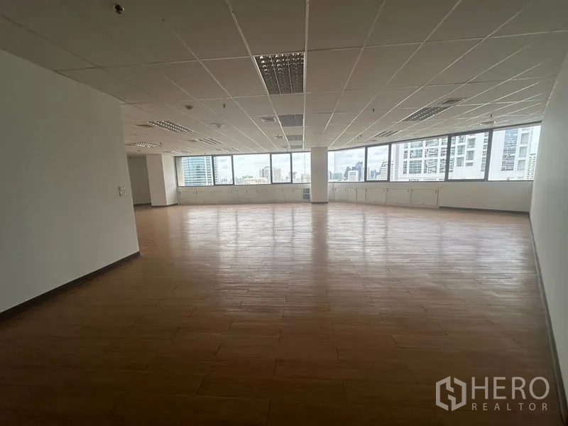 办公空间 出租在Bang Rak, Bangkok - 宽敞开放式办公区，木纹地板、格栅吊顶，大幅窗户可观赏曼谷天际线。