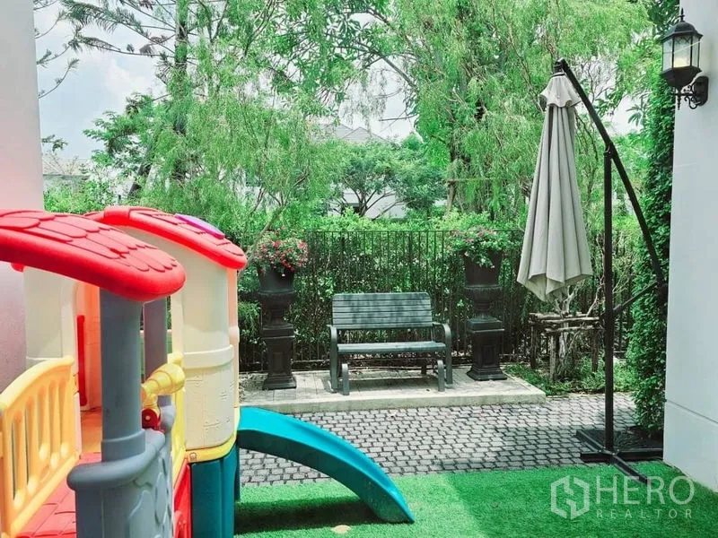 Detached House for rent or sale in Saphan Sung, Bangkok - Pocket garden with bench, umbrella and a children’s slide on artificial turf.