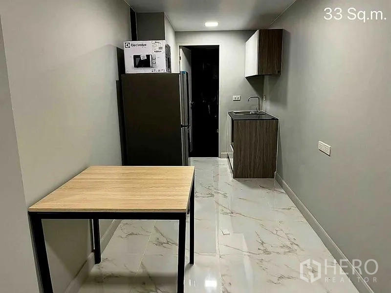 零售空间 出售在Khlong Toei, Bangkok - 走廊式小厨房，冰箱、水槽、吊柜和小桌。