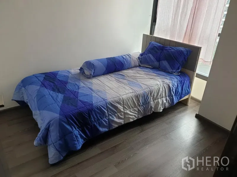 Condominium for rent in Watthana, Bangkok - Second bedroom with single bed and large window facing the city.