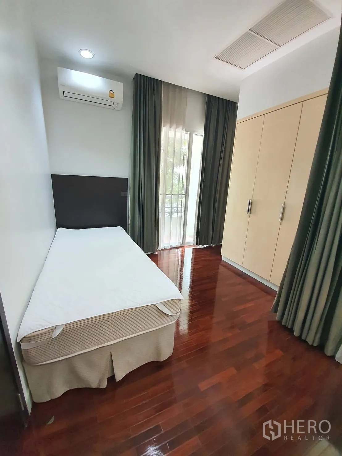 独栋房屋 for rent in Wang Thonglang, Bangkok - 卧室配单人床、内置衣柜、木地板、窗帘与空调。