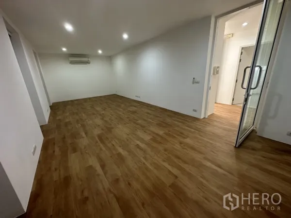 带办公室的家 出租在Phra Khanong, Bangkok - 宽敞空置办公空间，木地板、筒灯与玻璃门。