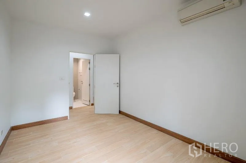 คอนโด ขาย - ห้องนอนว่างพื้นไม้ มีเครื่องปรับอากาศและทางเข้าห้องน้ำในตัว