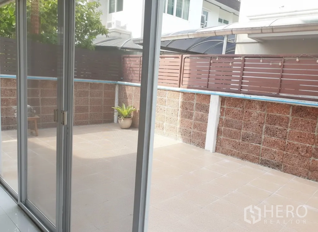 บ้าน ให้เช่าในLat Krabang, Bangkok - ลานระเบียงปูกระเบื้องส่วนตัว มองจากประตูกระจกบานเลื่อน พร้อมรั้วสูงให้ความเป็นส่วนตัว
