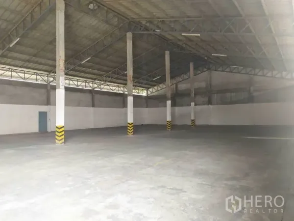 คลังสินค้า ให้เช่าในMueang Samut Prakan, Samut Prakan - ภายในโกดังโปร่งในอำเภอเมืองสมุทรปราการ หลังคาโครงเหล็กสูง เสาพร้อมแถบเตือน และพื้นคอนกรีตแข็งแรง